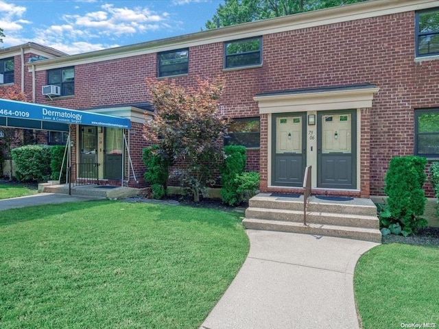 view of property with cooling unit and a front lawn