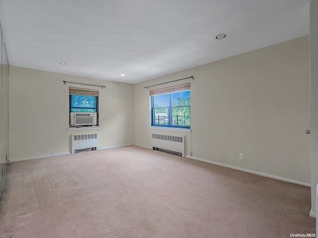 unfurnished room with light colored carpet and radiator