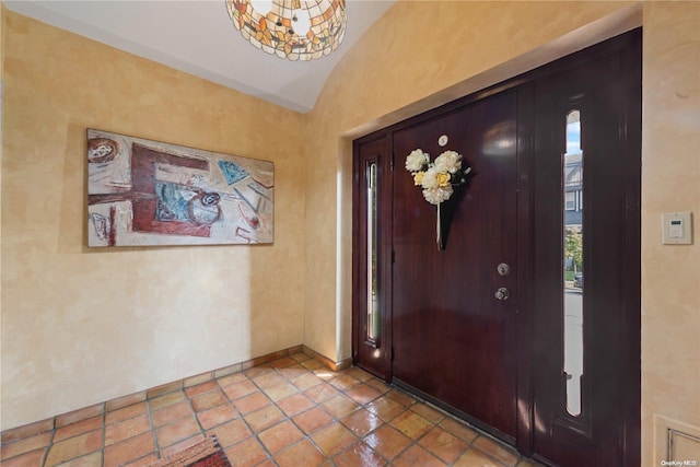 tiled entryway featuring lofted ceiling