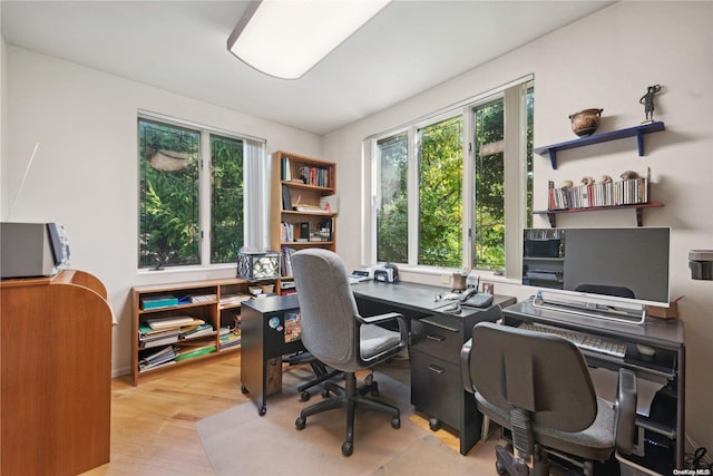 home office with light hardwood / wood-style floors