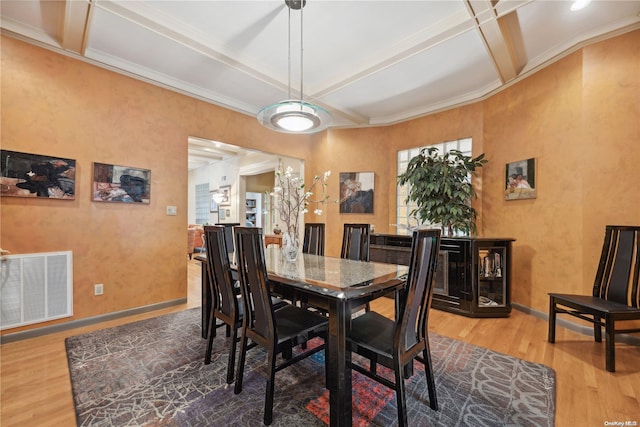 dining space with hardwood / wood-style floors, beamed ceiling, coffered ceiling, and ornamental molding