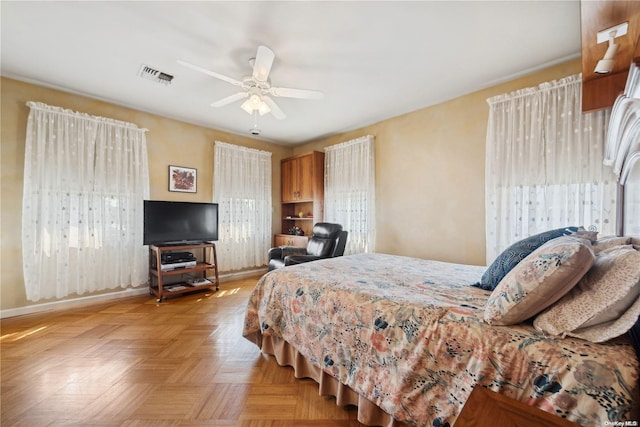 bedroom featuring light parquet flooring, multiple windows, and ceiling fan