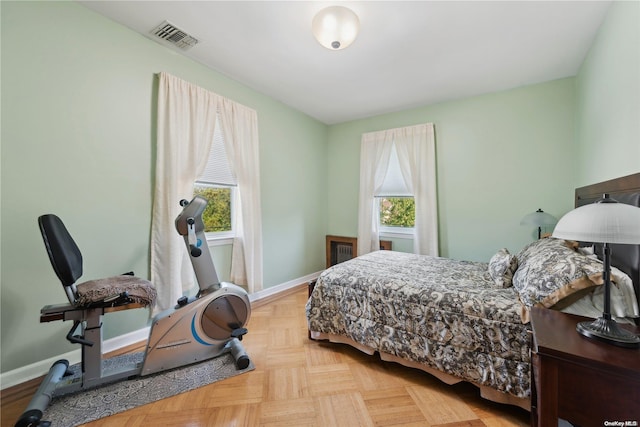 bedroom with multiple windows and light parquet floors