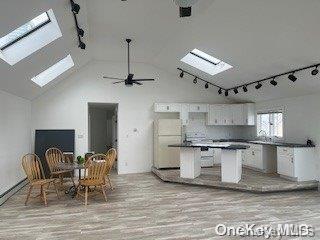 kitchen featuring white cabinets, light hardwood / wood-style floors, high vaulted ceiling, and ceiling fan