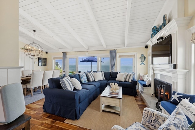 living room featuring lofted ceiling with beams, dark hardwood / wood-style flooring, a healthy amount of sunlight, and a notable chandelier