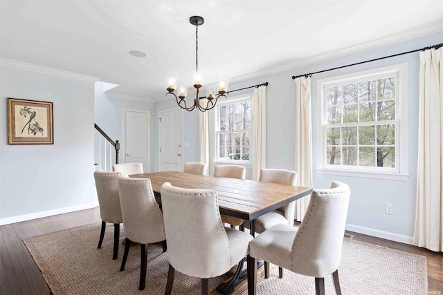 dining room featuring ornamental molding, a healthy amount of sunlight, dark hardwood / wood-style floors, and a notable chandelier