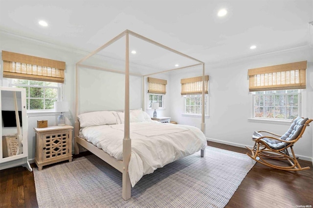 bedroom with multiple windows, ornamental molding, and hardwood / wood-style flooring