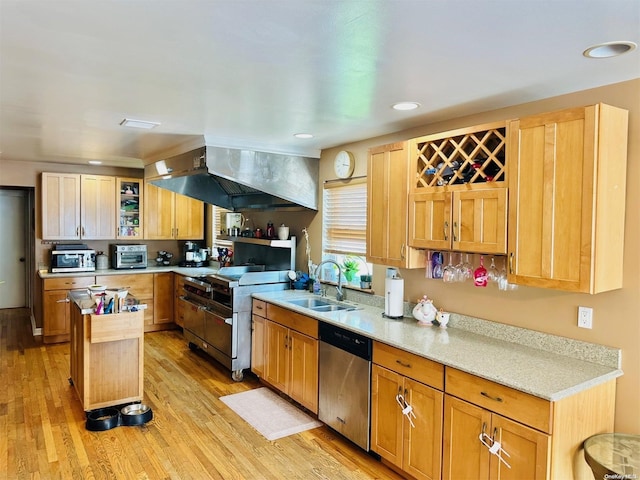 kitchen with sink, light stone counters, stainless steel dishwasher, high quality range, and light wood-type flooring