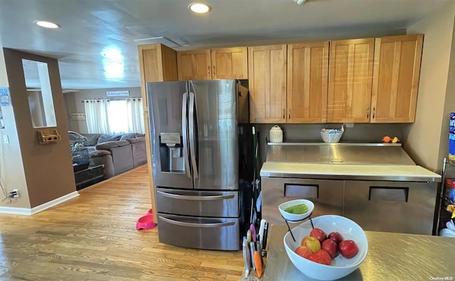 kitchen featuring stainless steel fridge and light hardwood / wood-style floors