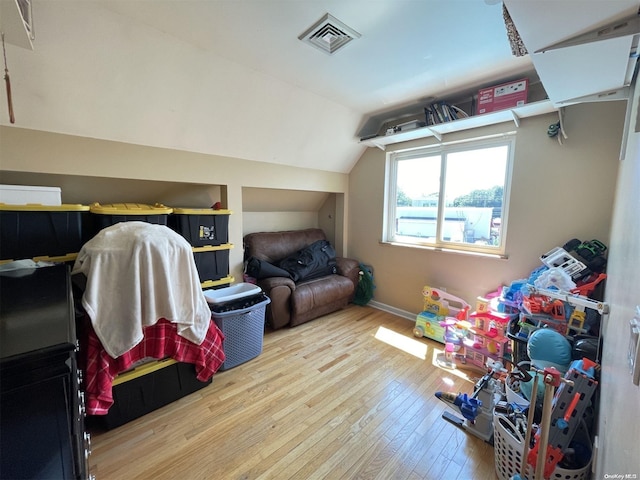 game room with light hardwood / wood-style floors and lofted ceiling