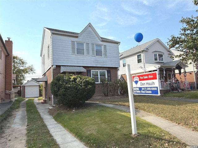 view of front of home with a garage, an outbuilding, and a front yard