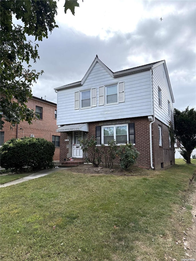 view of front of home featuring a front lawn and brick siding