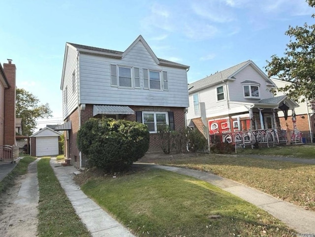 view of front facade with an outbuilding, driveway, brick siding, and a front yard