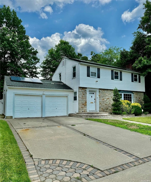 view of front of property with a garage and solar panels