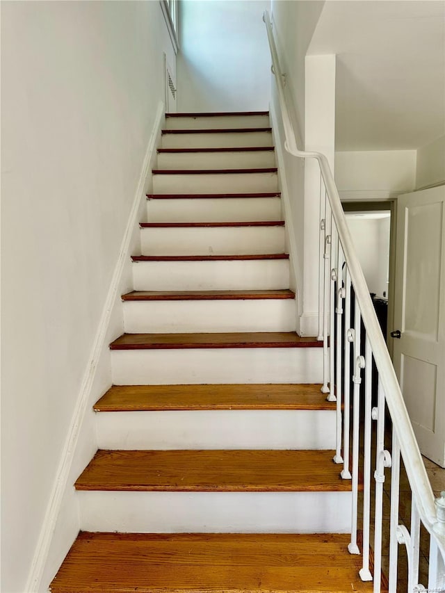 staircase with wood-type flooring