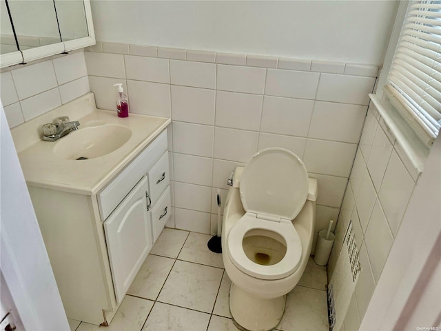 bathroom with tile patterned flooring, vanity, tile walls, and toilet