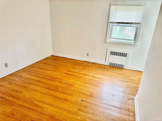 spare room with light hardwood / wood-style floors and radiator