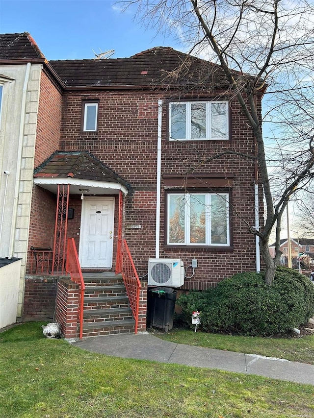 view of front of home with ac unit and a front lawn