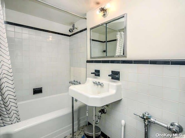 bathroom with shower / bath combo, sink, and tile walls