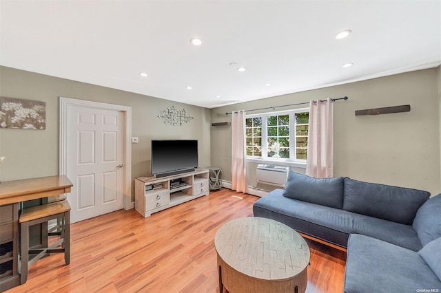 living room with light hardwood / wood-style flooring and a wall unit AC