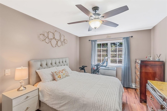 bedroom featuring ceiling fan, a baseboard radiator, and light hardwood / wood-style floors