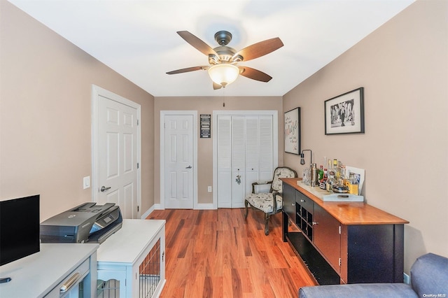 home office featuring ceiling fan and light hardwood / wood-style floors