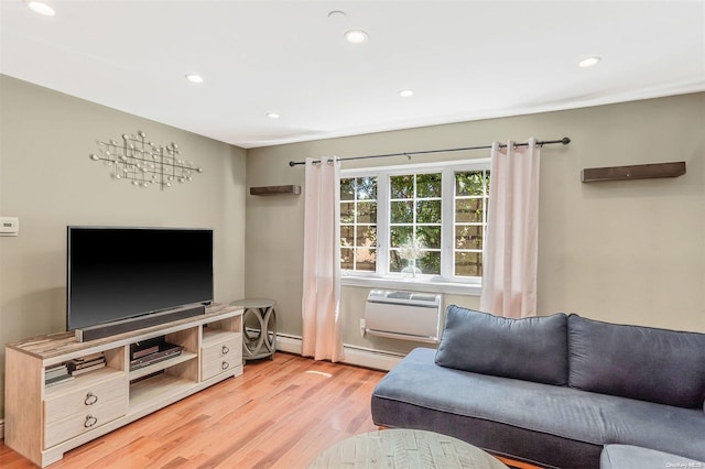 living room with a wall mounted AC, light wood-type flooring, and a baseboard heating unit