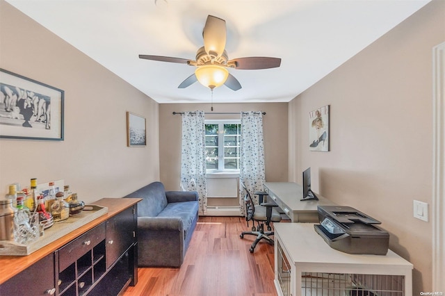 office space featuring ceiling fan, wood-type flooring, and a baseboard heating unit