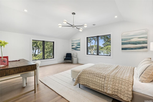 bedroom featuring a chandelier, hardwood / wood-style flooring, and vaulted ceiling