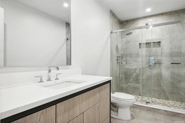 bathroom featuring tile patterned flooring, vanity, toilet, and walk in shower