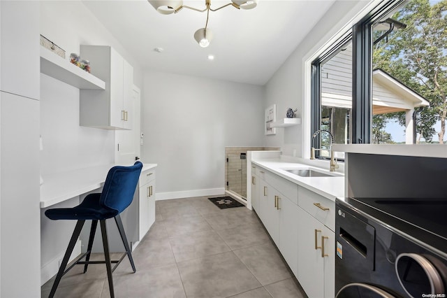 kitchen featuring light tile patterned floors, white cabinetry, and sink