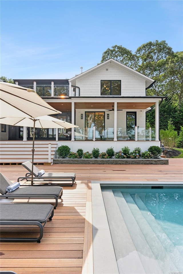 rear view of property featuring a swimming pool side deck