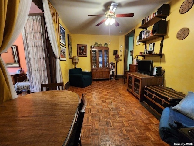 living area with ceiling fan and parquet floors