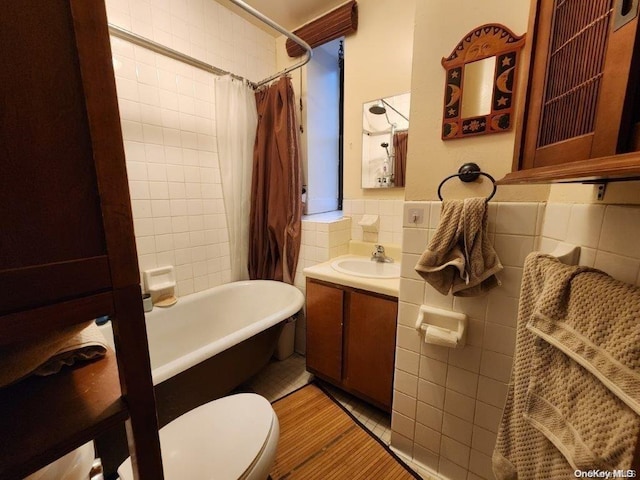 full bathroom featuring vanity, shower / bath combination with curtain, toilet, and tile walls