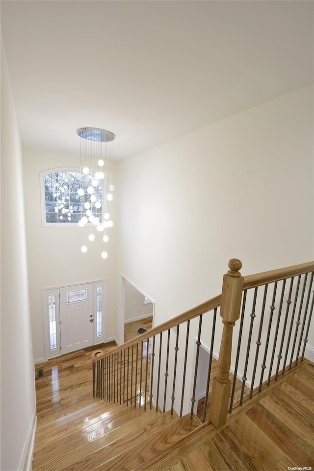 entryway featuring hardwood / wood-style flooring, a notable chandelier, and a high ceiling