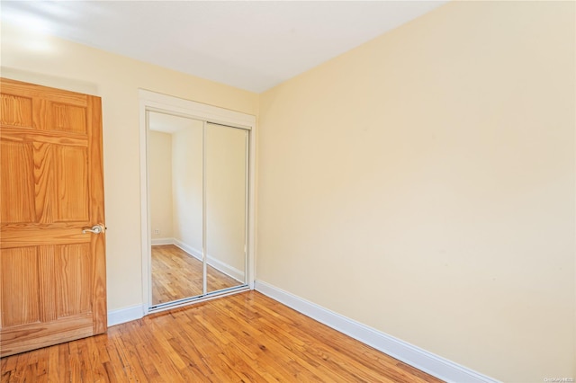 unfurnished bedroom featuring wood-type flooring and a closet