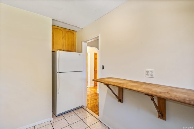 kitchen with white refrigerator and light tile patterned flooring