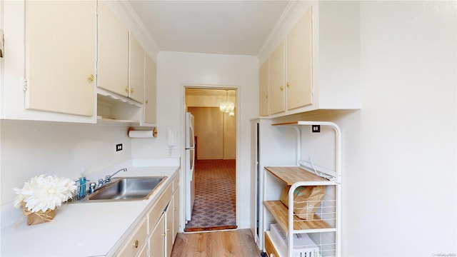 kitchen featuring white cabinets, white refrigerator, light wood-type flooring, and sink