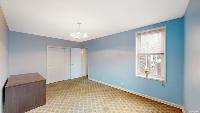 unfurnished bedroom featuring a chandelier, light carpet, and a closet