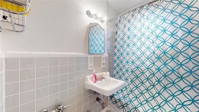 bathroom with a shower with curtain and tile walls