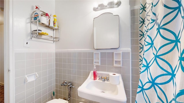 bathroom featuring sink, a shower with shower curtain, tile walls, and toilet