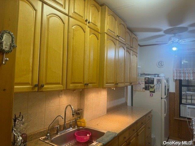 kitchen with decorative backsplash, ceiling fan, sink, and white refrigerator