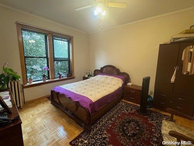 bedroom featuring ceiling fan, ornamental molding, and light parquet flooring