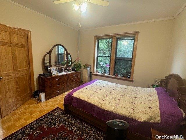 bedroom with ceiling fan, parquet floors, and ornamental molding