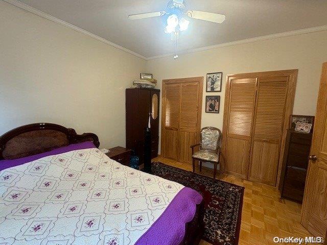 bedroom featuring parquet flooring, ceiling fan, and crown molding