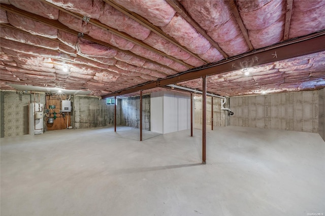 basement featuring electric panel and water heater