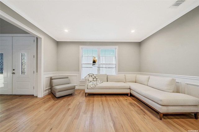 living room featuring crown molding and light wood-type flooring