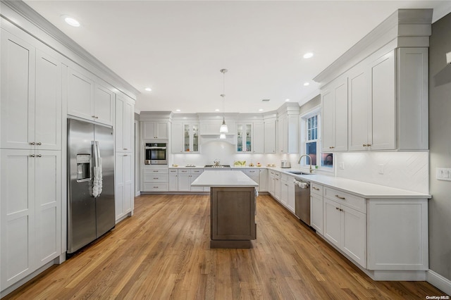 kitchen featuring pendant lighting, a center island, stainless steel appliances, and light hardwood / wood-style floors