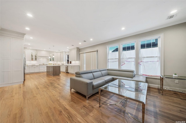 living room with light hardwood / wood-style floors and ornamental molding