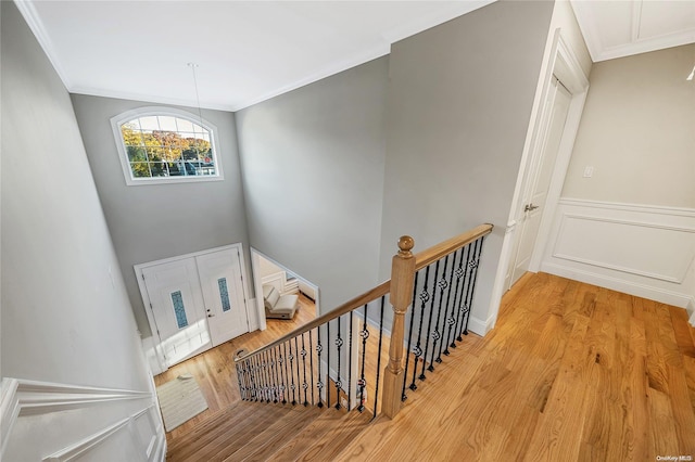 stairs featuring hardwood / wood-style flooring and crown molding